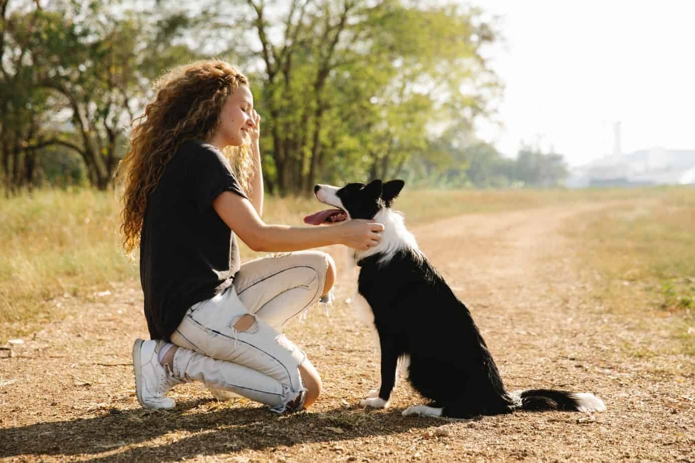 Wellness mit Hund, Frau und Hund sitzen bzw. knien voreinander und schauen sich liebevoll an. /Foto: pexels